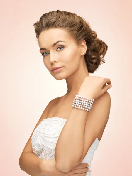 Mujer con pendientes de perlas y pulsera — Foto de Stock