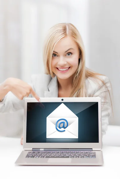 Vrouw met laptop wijzend op e-mail teken — Stockfoto