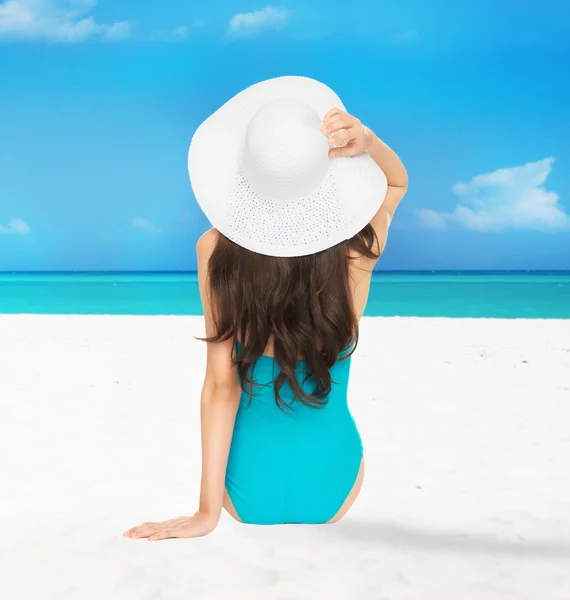 Model sitting in swimsuit with hat — Stock Photo, Image