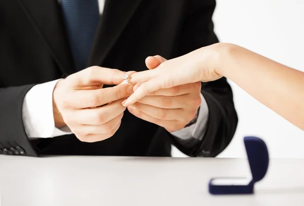 Мужчина надевает обручальное кольцо на руку женщине — стоковое фото