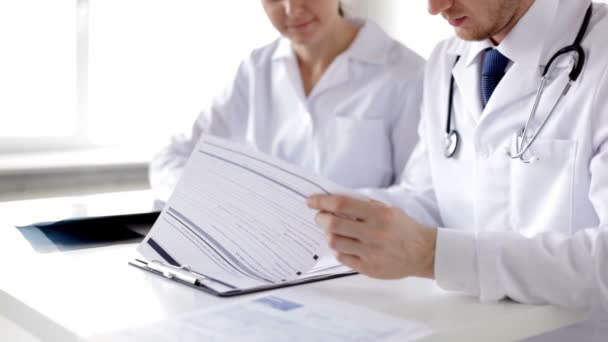 Closeup of two doctors with x-ray prints and papers — Stock Video