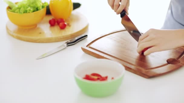 Footage of housewife cutting tomato in the kitchen — Stock Video