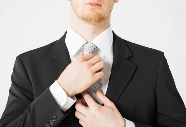 Homme ajustant sa cravate — Photo