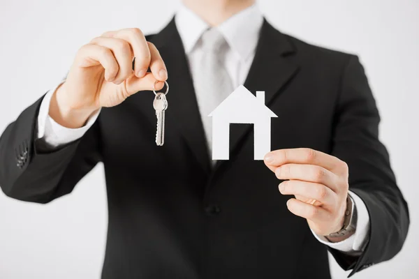 Man met huis sleutels en papier huis — Stockfoto