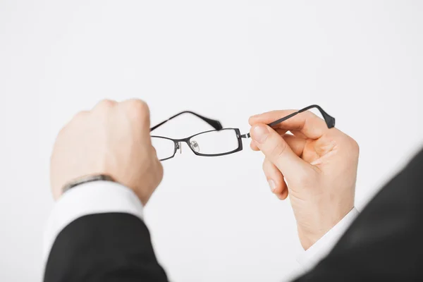Man hands holding eyeglasses — Stock Photo, Image