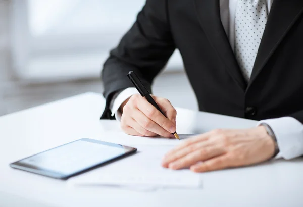 Man met tablet pc ondertekening van papier — Stockfoto