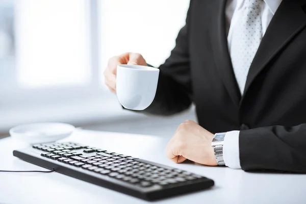 Man händerna med tangentbord dricka kaffe — Stockfoto