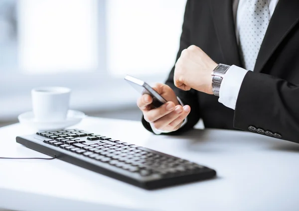 Männerhände mit Tastatur, Smartphone und Armbanduhr — Stockfoto