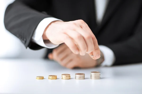 Homem colocando pilha de moedas em uma linha — Fotografia de Stock