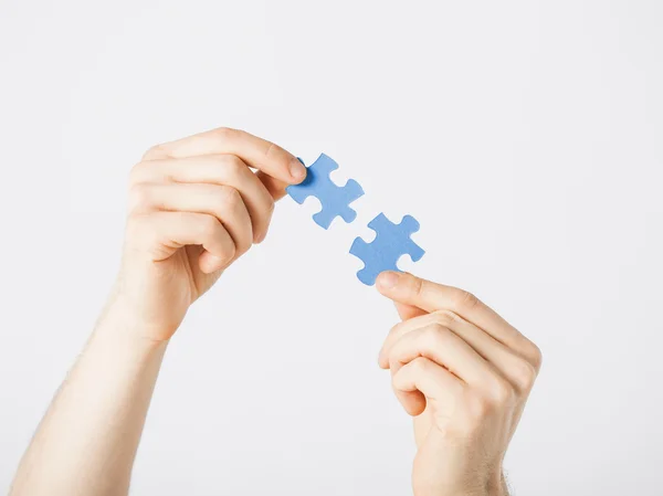 Two hands trying to connect puzzle pieces — Stock Photo, Image