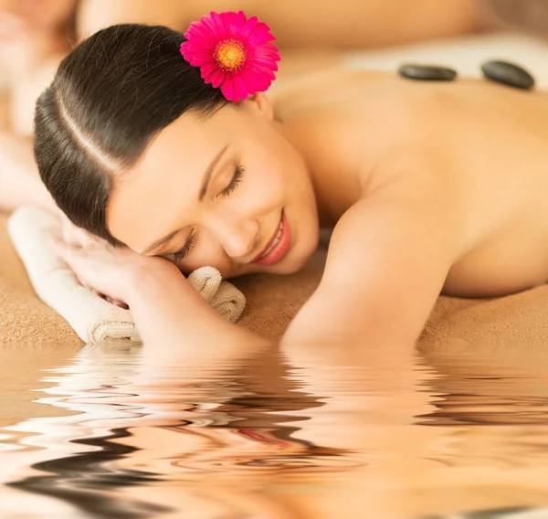 Vrouw in spa met hete stenen — Stockfoto