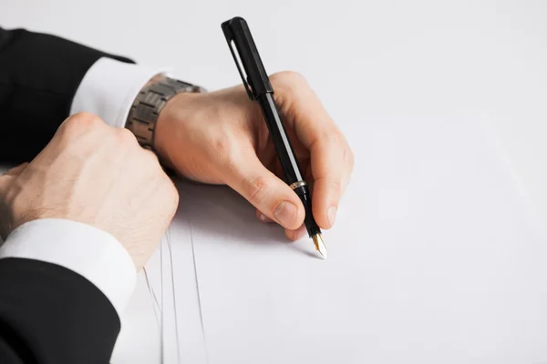 Empresário escrevendo algo no papel — Fotografia de Stock