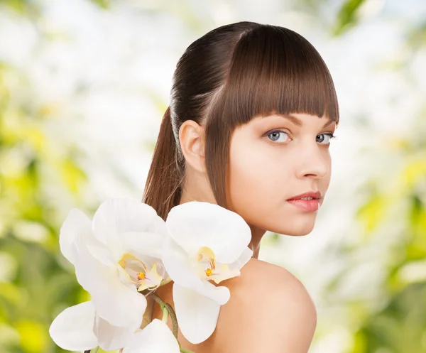 Piękna kobieta z kwiatem orchidei — Zdjęcie stockowe