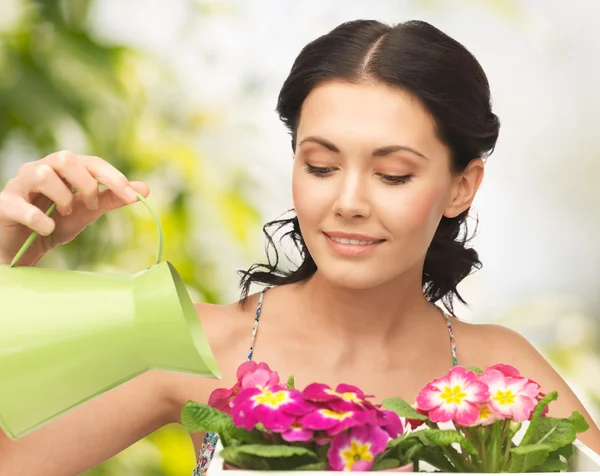 Dona de casa com flor em vaso e regador de lata — Fotografia de Stock