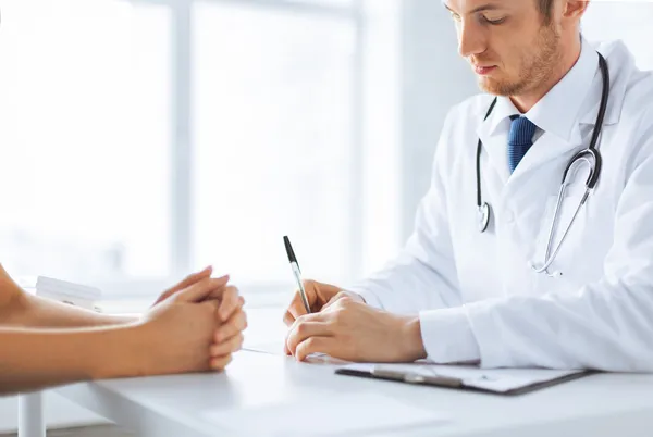 Paciente y médico tomando notas — Foto de Stock