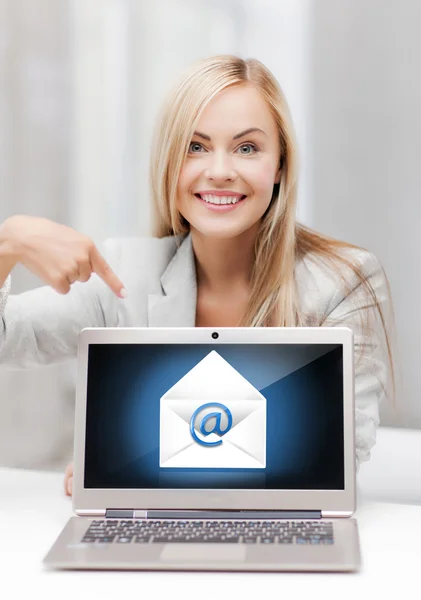 Woman with laptop pointing at email sign — Stock Photo, Image
