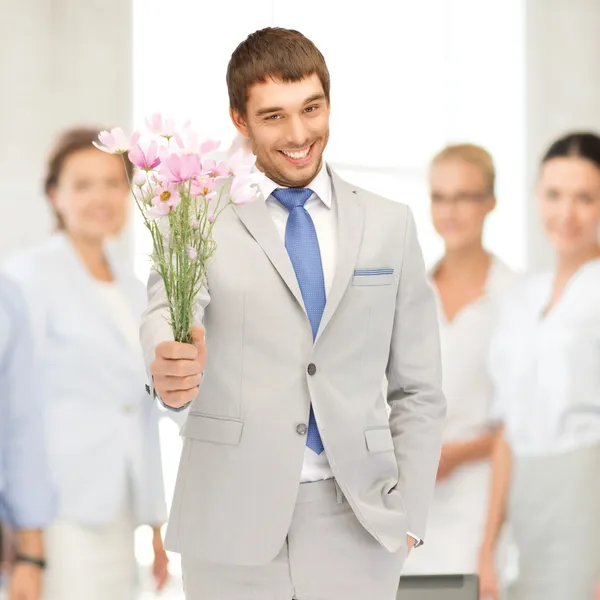 Pohledný muž s květinami v rukou — Stock fotografie