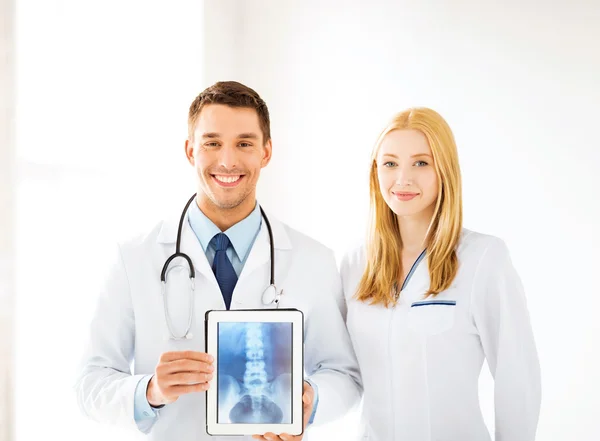 Two doctors showing x-ray on tablet pc — Stock Photo, Image