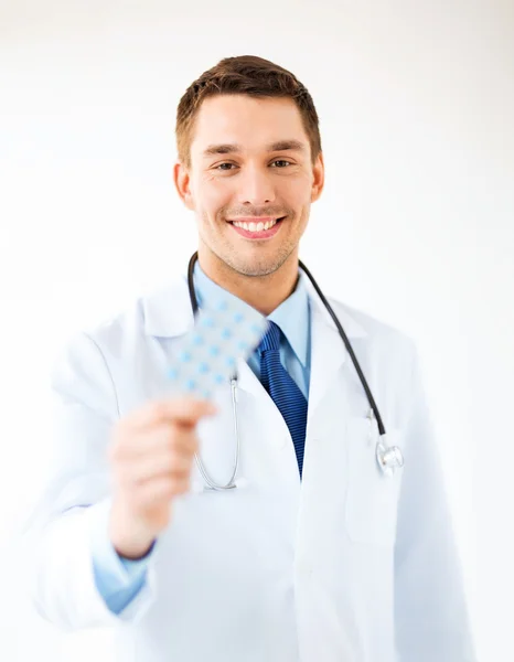 Young male doctor with pack of pills — Stock Photo, Image