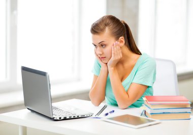 Stressed student with computer at home clipart