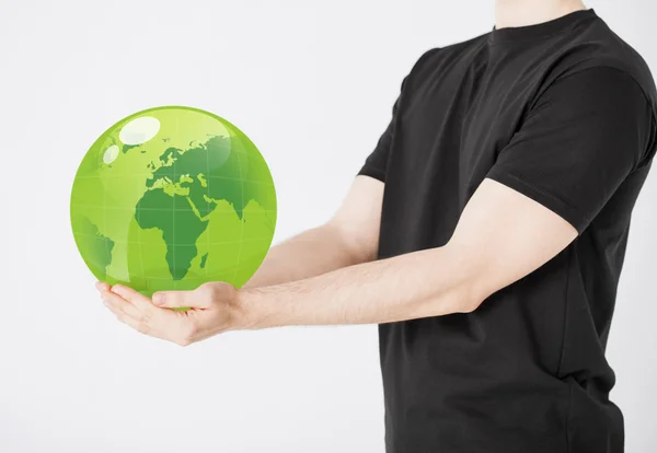 Человек держит зеленую сферу глобус — стоковое фото