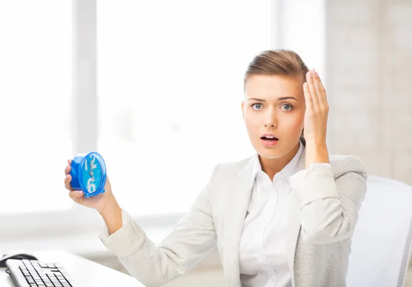 Empresária estressada segurando relógio — Fotografia de Stock