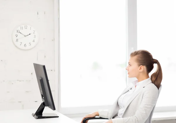 Mujer de negocios mirando el reloj de pared en la oficina — Foto de Stock