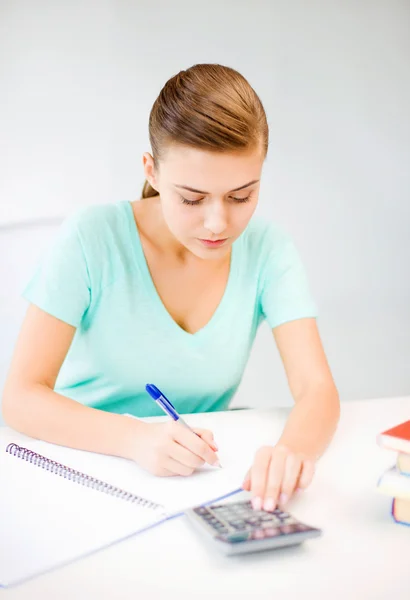 Menina estudante com notebook e calculadora — Fotografia de Stock