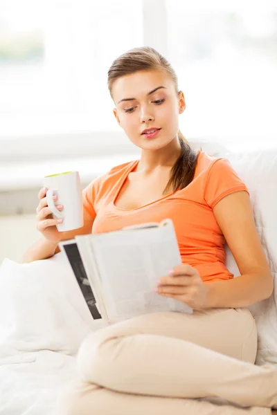 Frau mit Tasse Kaffee und Magazin zu Hause — Stockfoto