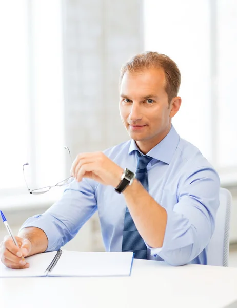 Empresario con gafas escribiendo en cuaderno —  Fotos de Stock