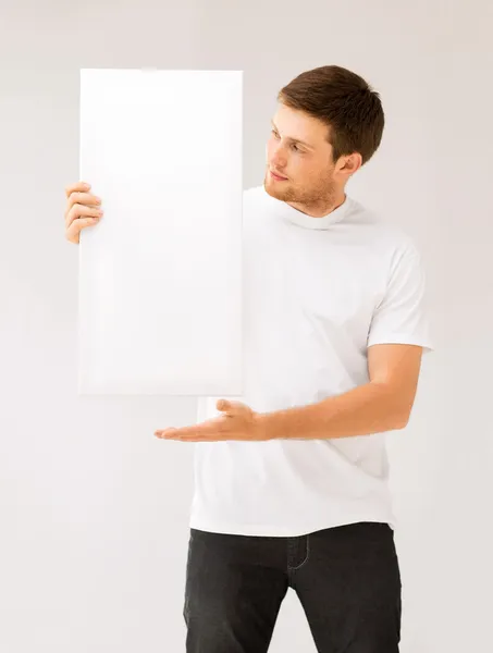 Jovem segurando placa branca em branco — Fotografia de Stock