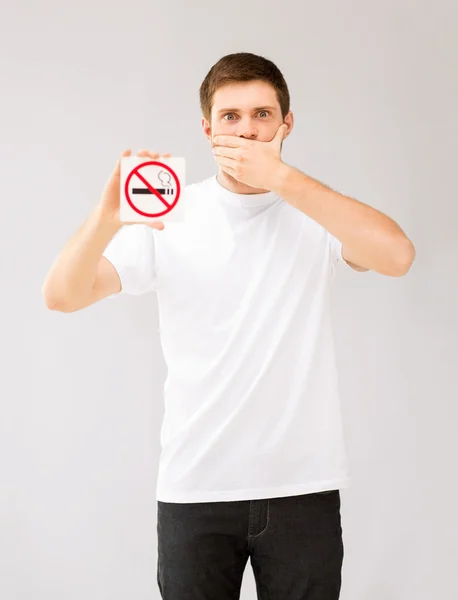 Giovane uomo che tiene segno di non fumare — Foto Stock