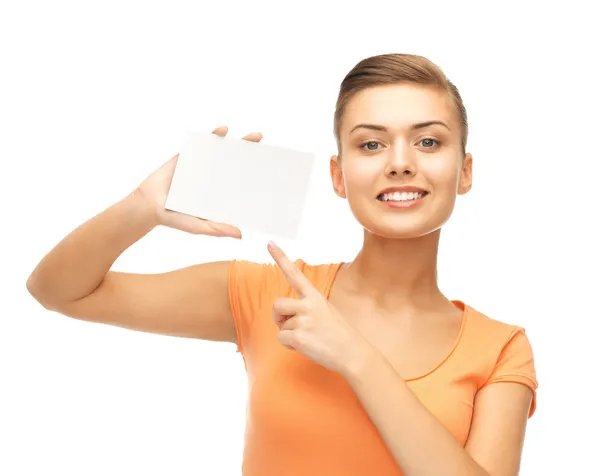 Smiling woman pointing at white blank card — Stock Photo, Image