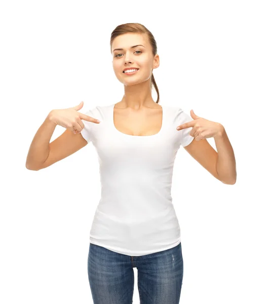 Mujer sonriente apuntando a la camiseta blanca en blanco — Foto de Stock