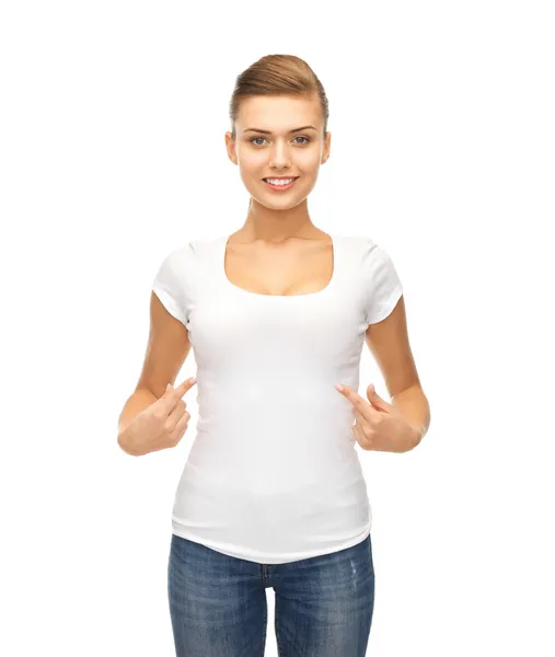 Smiling woman pointing at blank white t-shirt — Stock Photo, Image