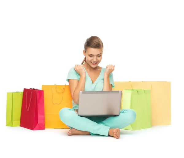 Vrouw met laptop en shopping tassen — Stockfoto