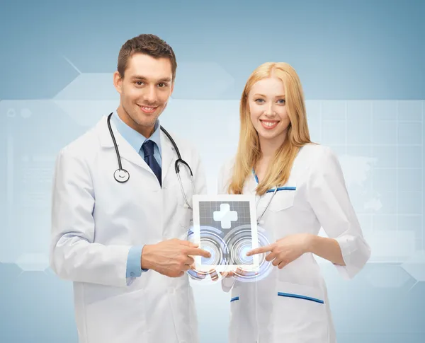 Young doctors pointing at tablet pc — Stock Photo, Image