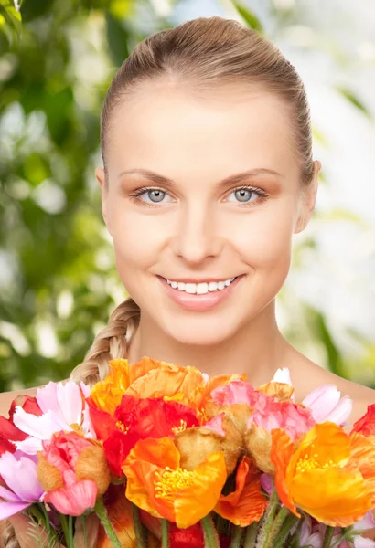 Härlig kvinna med röda blommor — Stockfoto