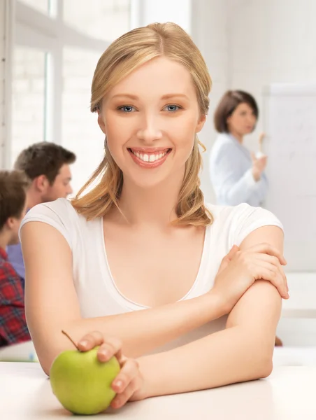 Beautiful girl with green apple at school — Stock Photo, Image