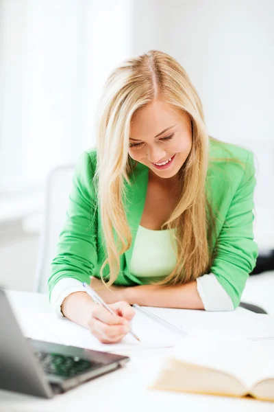 Chica estudiante sonriente escribiendo en cuaderno — Foto de Stock