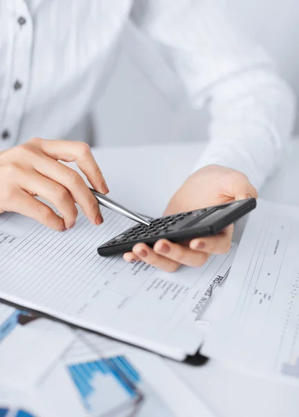 Woman hand with calculator and papers — Stock Photo, Image