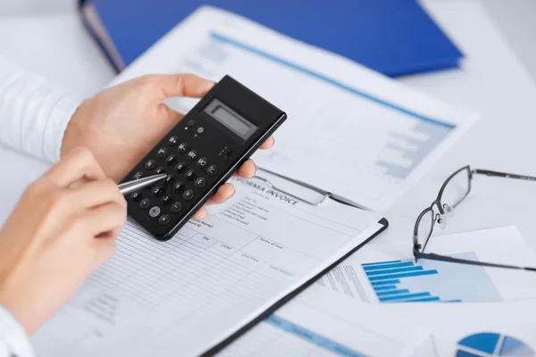 Mujer mano con calculadora y papeles —  Fotos de Stock