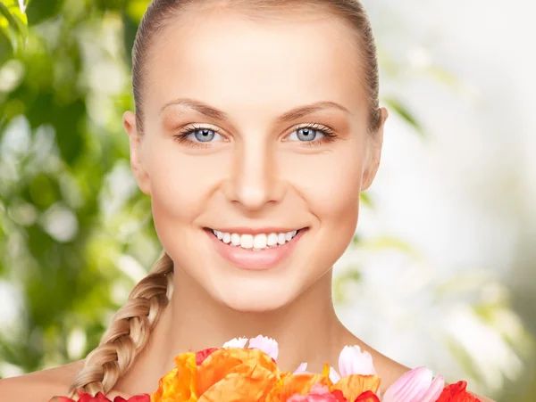 Schöne Frau mit roten Blumen — Stockfoto