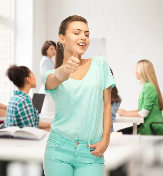 Lächelndes Mädchen im farbigen T-Shirt, das die Daumen nach oben zeigt — Stockfoto