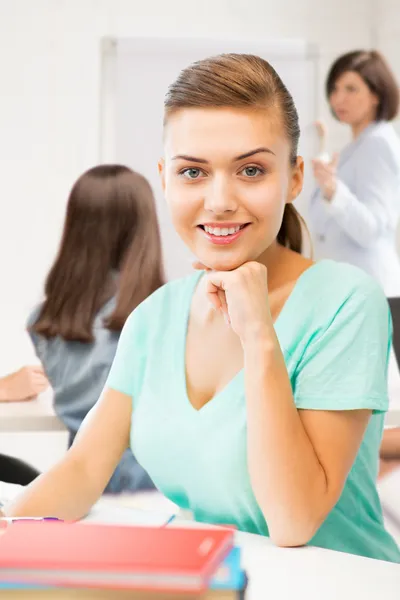 Glada leende student tjej med böcker i skolan — Stockfoto