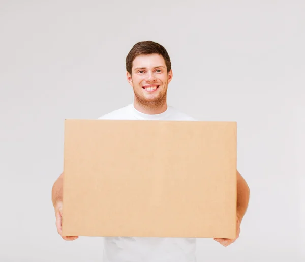 カートン箱を運ぶ男の笑みを浮かべてください。 — ストック写真