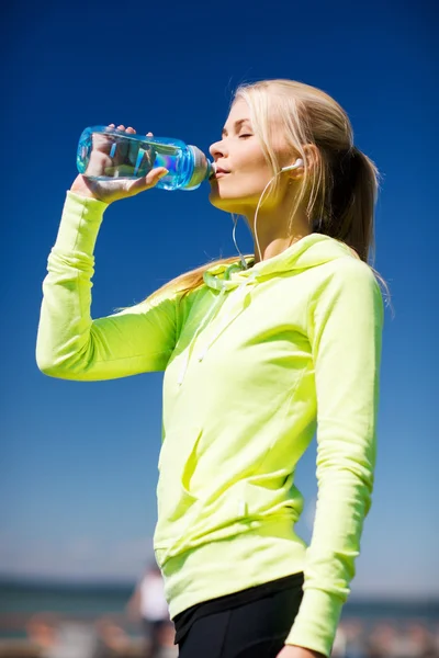 Mujer beber agua después de hacer deportes al aire libre — Foto de Stock