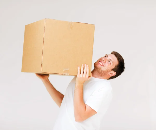 Человек с тяжёлой коробкой — стоковое фото