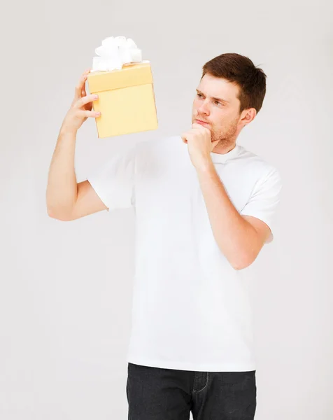 Man in white t-shirt with gift box — Stock Photo, Image