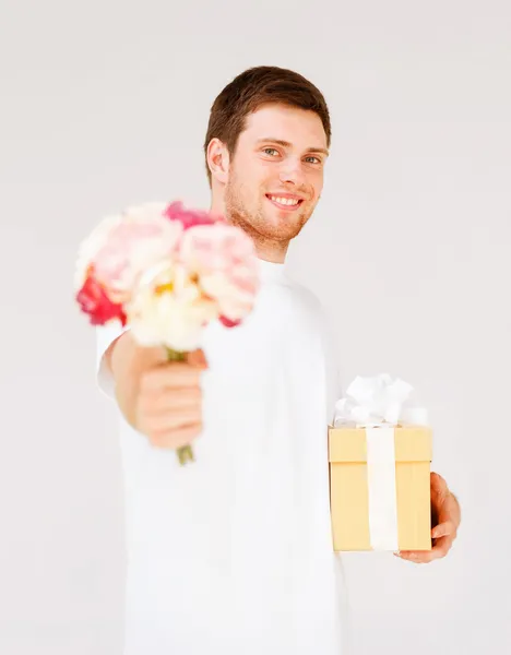 Uomo in possesso di mazzo di fiori e scatola regalo — Foto Stock